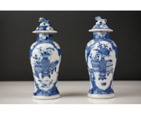 Near Pair of Chinese Porcelain Baluster Blue and Lidded Vases decorated with flowers in vases scenes, Kangxi four character m