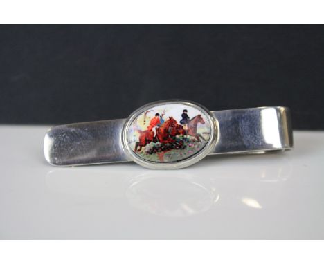 A silver document clip with enamel panel depicting horses. 