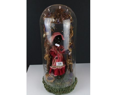A musical automaton, modelled as a female figure beneath a floral bower on velvet base beneath a glass dome, marked "The Magi