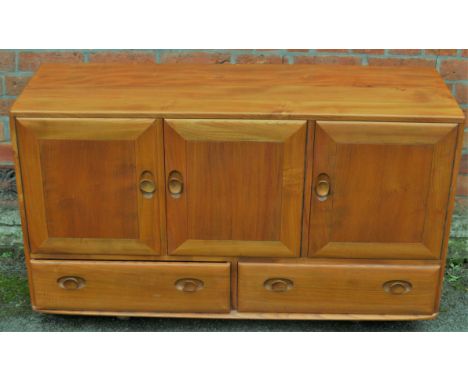 An Ercol light elm sideboardHaving three paneled cupboard doors, length 129cm 