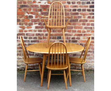 An Ercol-style light oak dining suite Comprising drop-leaf oval table and four splat back chairs to include one carver