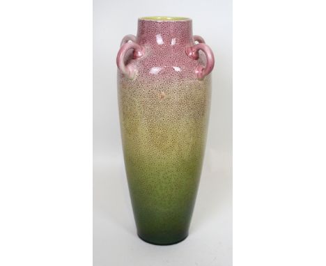 A large Arts & Crafts ceramic vase Of tapering form with four handles, having printed floral decoration on a pink, yellow and