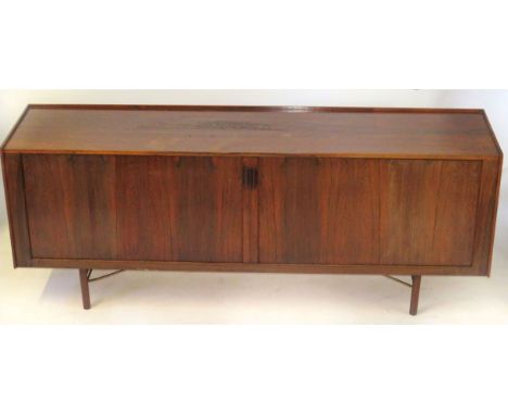 A Scandinavian rosewood sideboard Having two roller shutter doors enclosing an assortment of drawers and shelves, length 206c