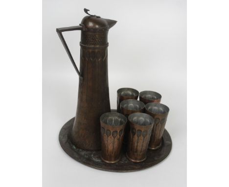An Arts & Crafts Riggenbach copper eight piece drinks set Comprising jug, six goblets and circular tray, the tray having impr