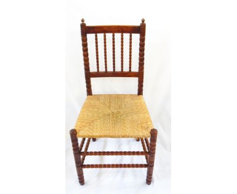 Ernest Gimson yew rush-seated chair made by Edward Gardiner with two pointed finials to the bobbin uprights, having bobbin sp
