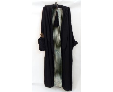 A black silk evening coat bearing the label Elise Kreutzer, lined with green and black striped silk, ribbon detail embroidere