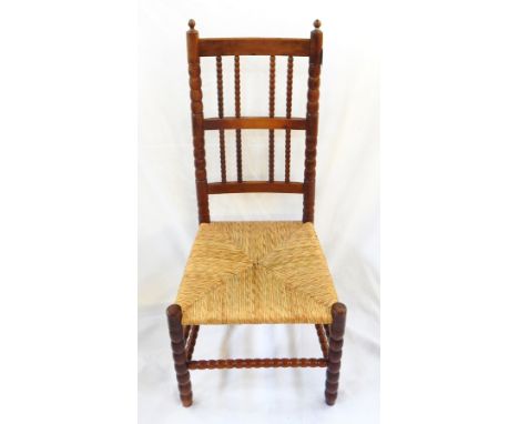 Ernest Gimson yew rush-seated chair made by Edward Gardiner with two pointed finials to the bobbin uprights, having two tiers
