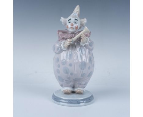 A glossy figure of a clown in serene colors. This item comes with its original box, measuring 9.5"L x 5.5"W x 6"H. Lladro bac
