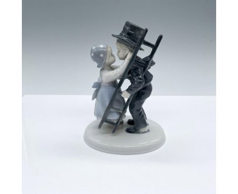Glossy figure of a young girl pulling a young chimney sweep boy for a kiss. Metzler &amp; Ortloff backstamp. Issued: 20th cen