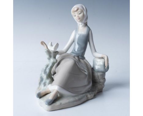 Glossy figure of shepherdess holding a dove, capturing a serene and pastoral moment. This item has its original box, measurin