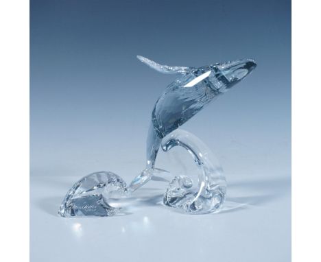This is a pale blue crystal figure that depicts a humpback whale in a mid-roll position over a clear crystal wave. Also inclu