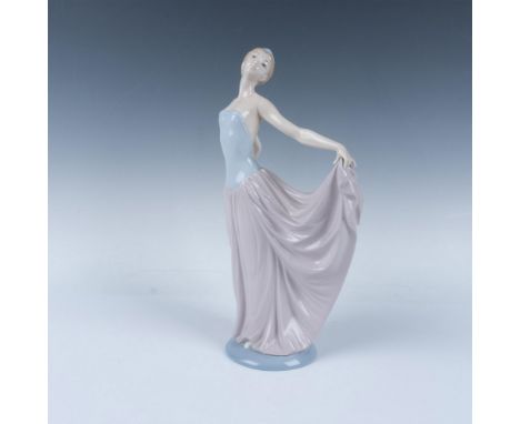 A glossy porcelain figure of a dancer in an elegant pose. This item has its original box, measuring 12.5"L x 10.25"W x 6"H. L