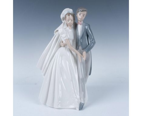 A glossy figure of bride and groom. Nao Lladro backstamp. Issued: 20th centuryDimensions: 8"L x 6"W x 10.5"HManufacturer: Nao