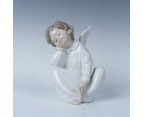 Young figure seated in peaceful contemplation with his head resting gently on hand, adorned in a flowing white robe, and maje