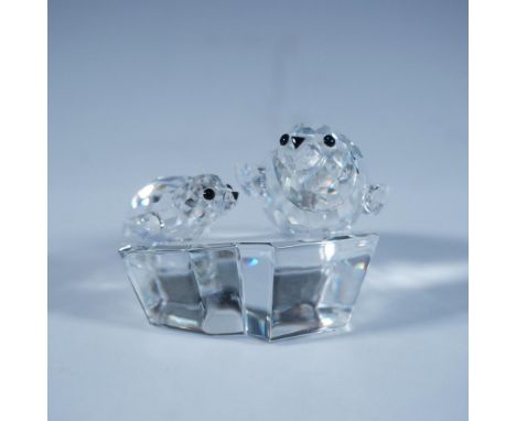 A clear faceted figure of a mother seal and her pup, both with black eyes and nose, resting atop a clear smooth ice floe. 199
