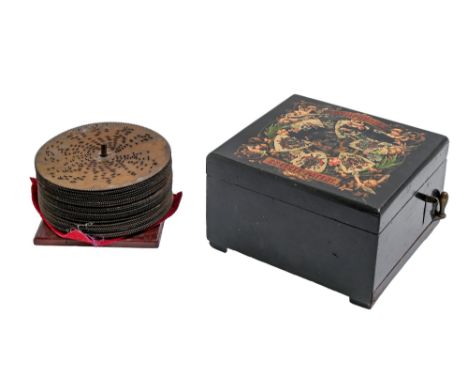 A Symphonion disc music box, late 19th c, to play 14.8cm metal discs, in ebony case with polychrome transfer to the lid, 19 x