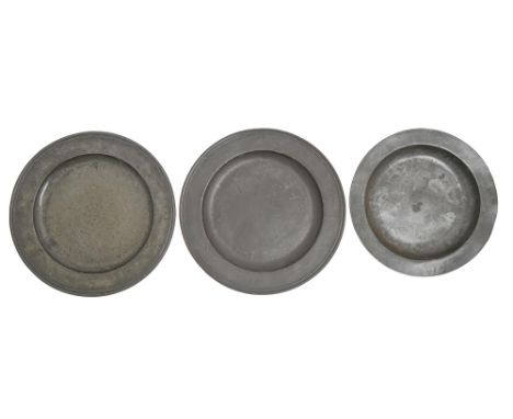 Two English pewter chargers, 18th c, one engraved with tulip flanked by initials TM, 46cm diam, pseudo hallmarks and a smalle