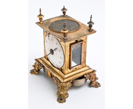 A gilt brass table clock, 19th c and earlier, with&nbsp;silver, possibly champleve, dial to the top of the case, two strapped