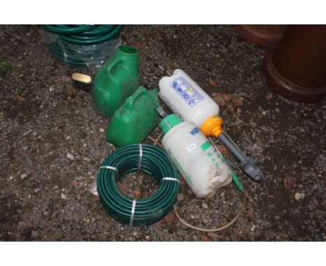A fuel can, hose pipe, two sprayers and a watering can