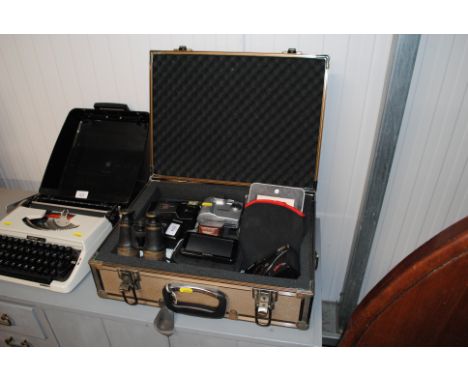 A case containing various cameras to include polaroid, Garmin Sat Nav etc.