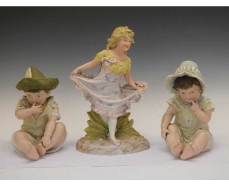 Pair of early 20th Century Continental 'Piano Babies' and bisque figure of young girl, 41cm high and smaller