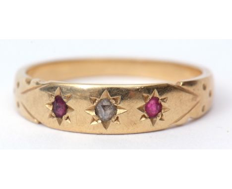 18ct stamped diamond and ruby ring, the centre a small diamond flanked by 2 small circular cut rubies, each in star engraved 