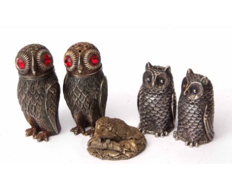 Mixed Lot: two pairs of base metal pepper casters, each modelled in the form of owls, together with a model of a hedgehog, la
