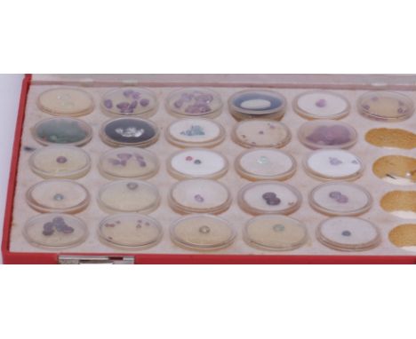 Red rectangular case containing 26 circular boxes, cut semi-precious stones and 4 pearl finial sticks  