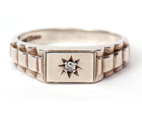 White metal and small diamond ring, the plain polished rectangular panel features a small brilliant cut diamond in a star eng