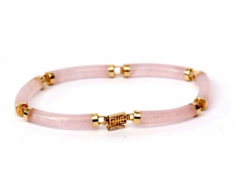 Modern yellow metal and pink jade articulated bracelet, the six cylindrical jade links each capped with yellow metal terminal