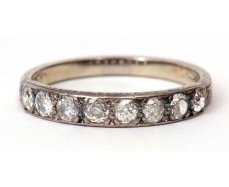 Precious metal diamond set half eternity ring featuring 8 small diamonds, claw set between part foliate engraved shoulders, s