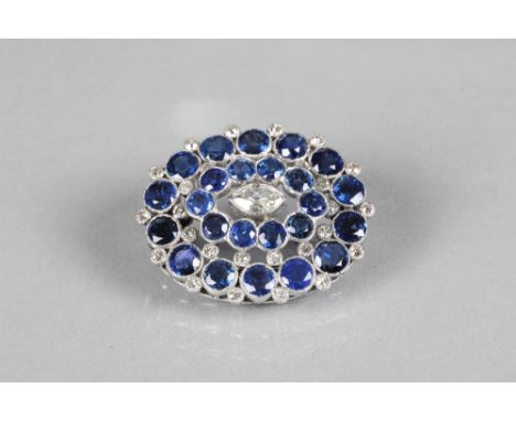 Ladies diamond and sapphire brooch set in white gold, central marquise cut diamond surrounded by two rows of sapphires inters