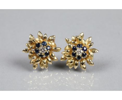 Pair of diamond and sapphire earrings, central diamond surrounded by 6 small sapphires mounted on yellow metal, central diamo