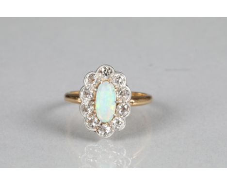 Diamond and opal ring, central oval opal surrounded by ten 0.1 carat diamonds on a yellow metal shank