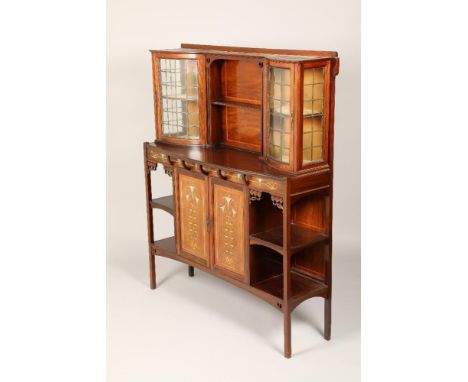 An Art Nouveau mahogany cabinet, twin leaded glass cabinets with central shelf above inlaid floral frieze above twin doors in