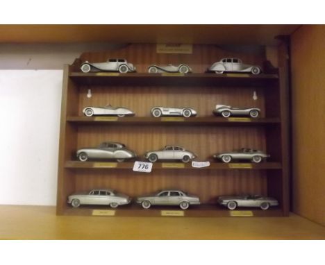 A DISPLAY SHELF OF JAGUAR CLASSIC MOTOR CARS IN PEWTER BY THE DANBURY MINT