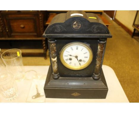 A late Victorian black slate two hole mantel clock with key