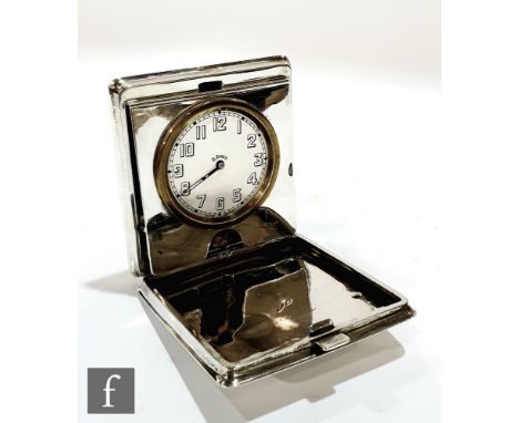 A hallmarked silver folding travel clock, the square case with engine turned decoration opening to circular white enamelled d