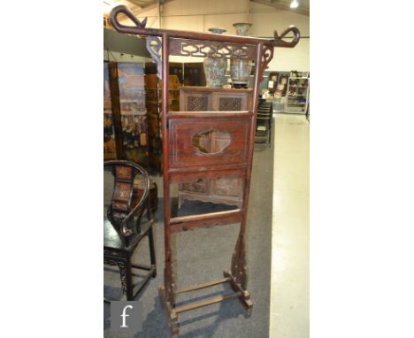 A Chinese huanghuali style robe stand, the tubular supports with scroll top and openwork panels, raised on yoke form supports