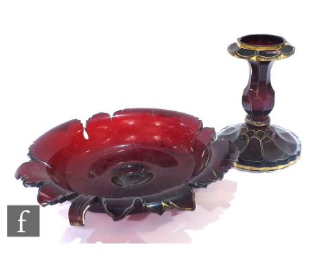 A large 19th Century Bohemain ruby glass pedestal taza with a shallow leaf form dish with partial gilded decoration mounted t