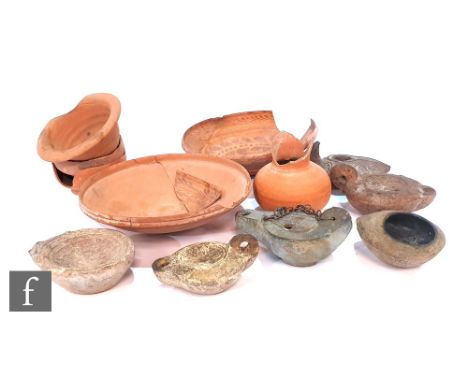 A Roman oil lamp with portrait roundel, damaged, three others of various ages, a souvenir cast metal oil lamp, two small terr