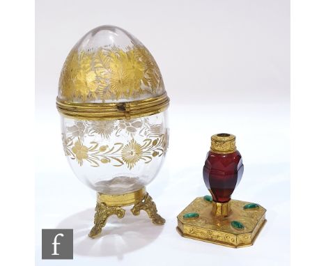 A 19th Century ruby glass facet cut scent bottle with fine engraved gilded mounts, raised to a square base set with malachite