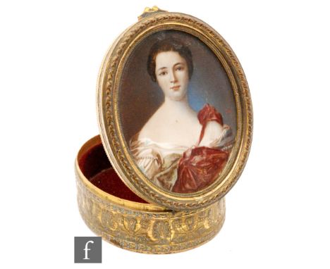 A late 19th and early 20th Century French gilt oval box painted with a portrait of a lady wearing a red dress above a border 