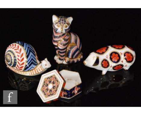 A collection of three Royal Crown Derby paperweights comprising a pig, a cat and a snail together with a hexagonal trinket po