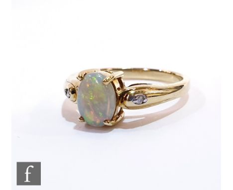 A 9ct hallmarked opal and diamond three stone ring, central oval claw set opal flanked by a diamond to either side, ring size