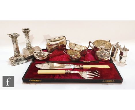 A small parcel lot of assorted hallmarked silver items to include a pair of candlesticks, a cream jug, sugar basin, condiment