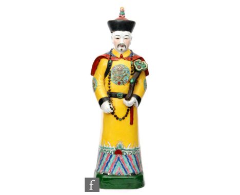 A Chinese Republic Period (1912-1949) figure of a high-ranking official modelled in standing position wearing yellow robe wit