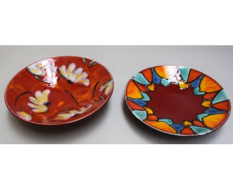 Two Poole Pottery dishes, one decorated with white daisies on red ground, the other with abstract petals in iridescent colour