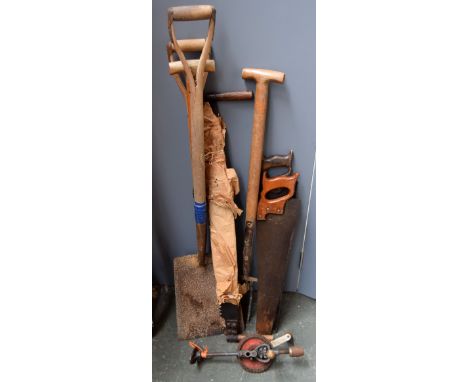 A small collection of vintage tools, including spades and saws