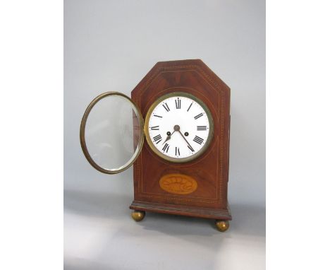A late 19th/early 20th century walnut and boxwood inlaid mantel clock, inlaid with conch shell, the enamel two train dial wit